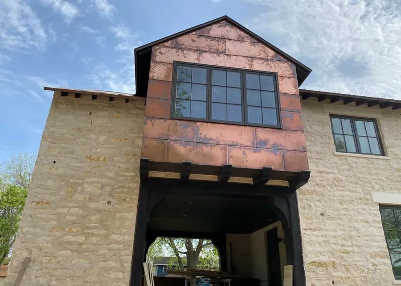 Copper metal panel facade on a stone building for Skylight Installation in Kaukauna