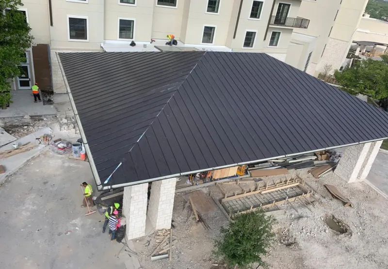 Metal roofing installation team working on a commercial building in Kaukauna